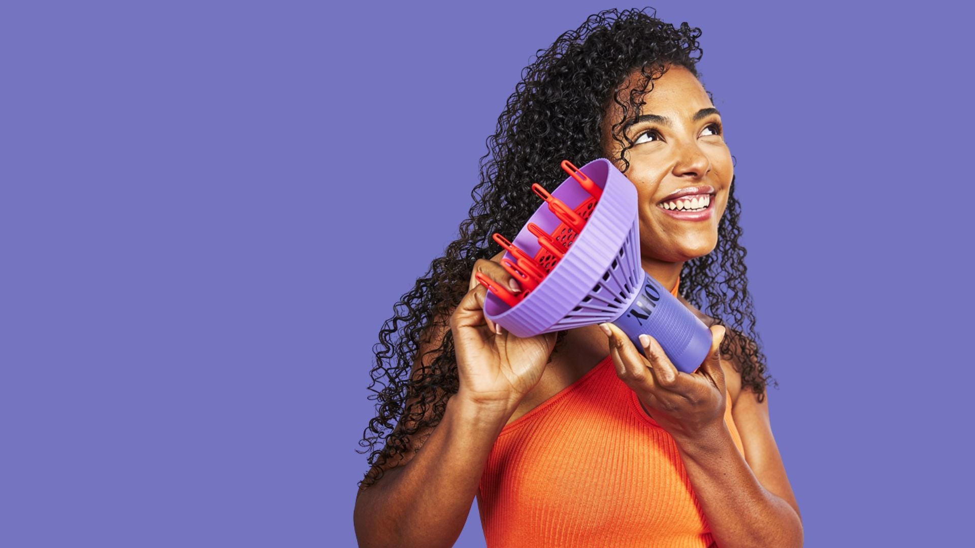 Woman holding orange and purple curl flow diffuser