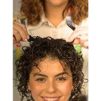 HAPPY GIRL WITH VOLUME COMBS CREATING LIFT IN HER BRUNETTE CURLS