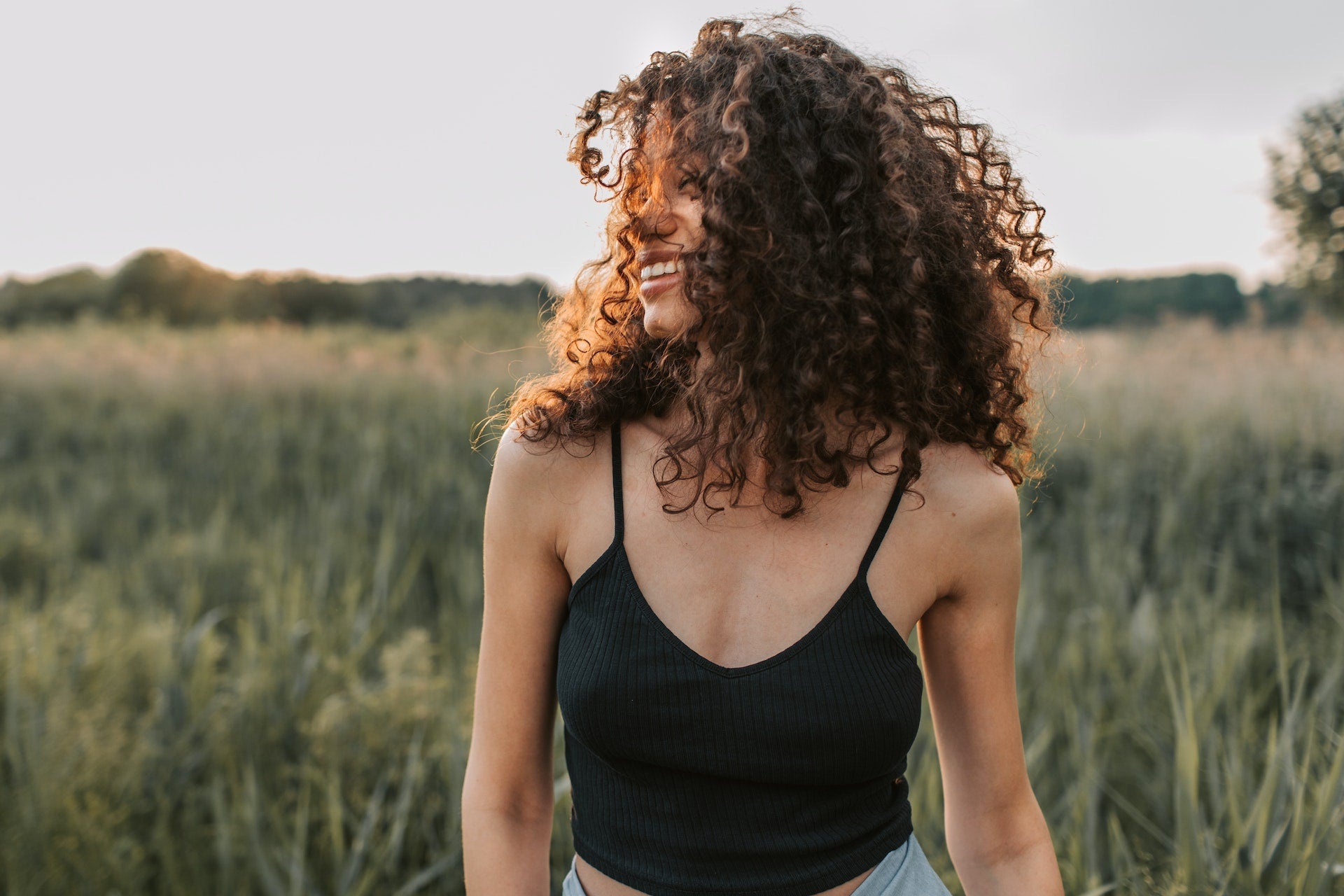 lady with 3c curls in a field