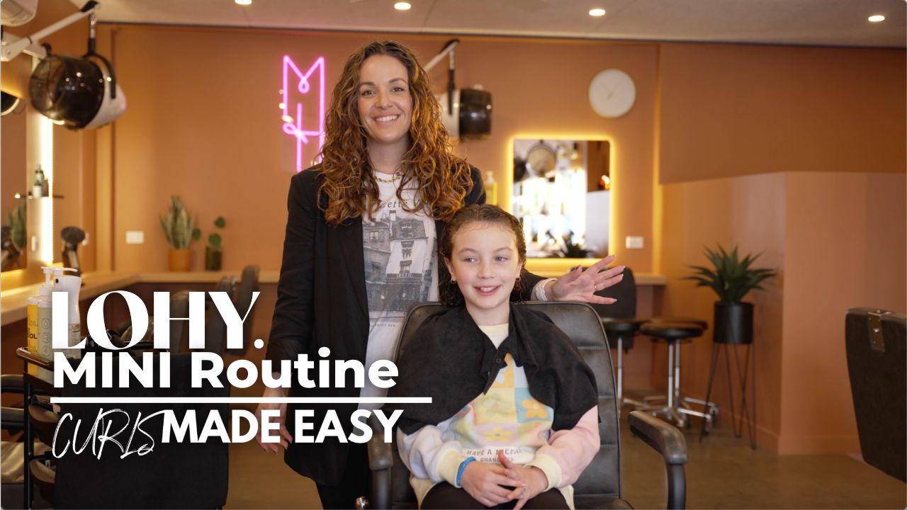 text saying "LOHY. MINI Routine Curls Made Easy", child girl with curly blonde hair, sitting in salon chair looking to side of camera, and Jonina from LOHY. standing behind chair with wavy brunette hair smiling.